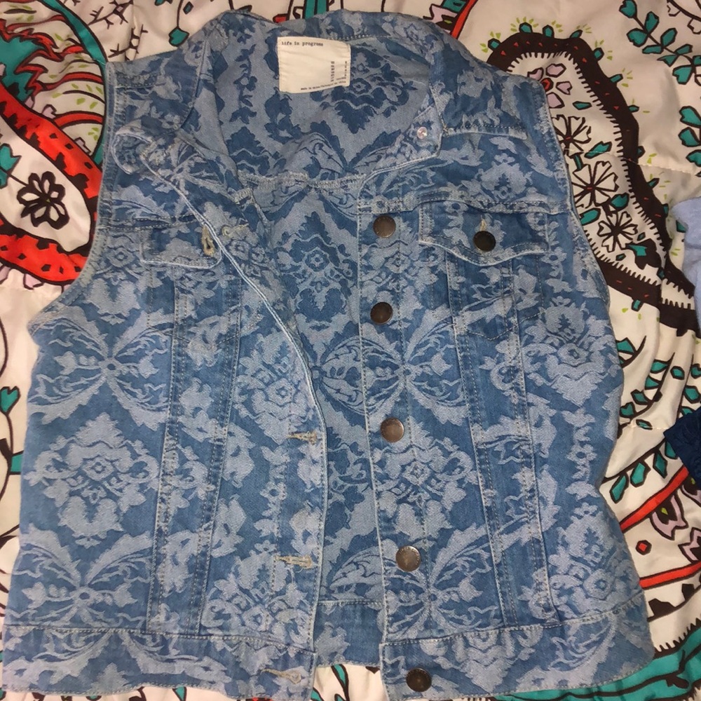 Jean Jacket with no sleeves and print on it.